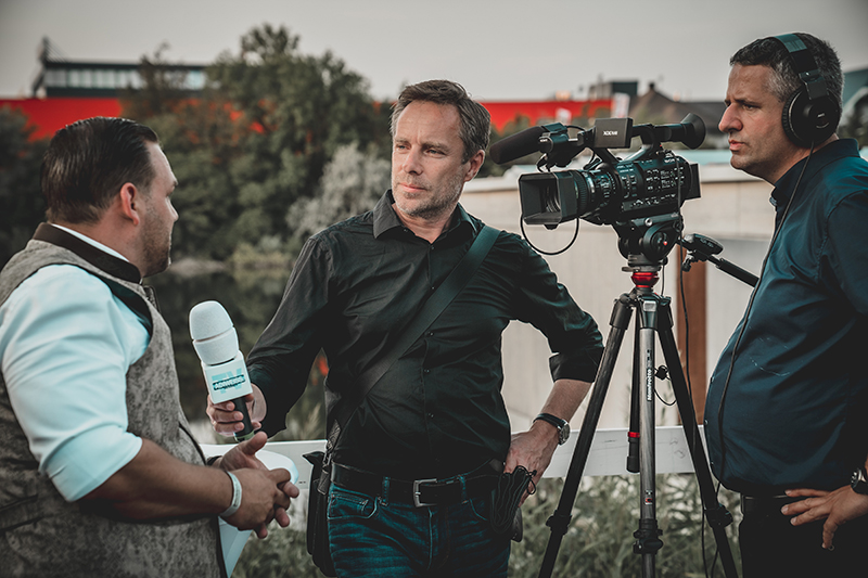 trois journalistes avec un camera dehors